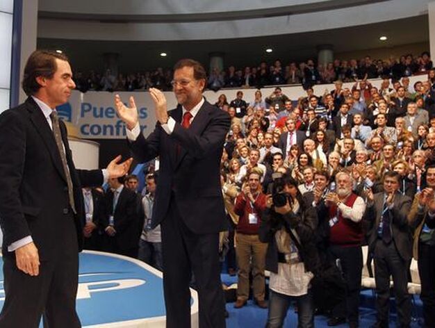 El ex presidente del Gobierno, Jos&eacute; Mar&iacute;a Aznar, saluda a los asistentes junto al n&uacute;mero uno del Partido Popular, Mariano Rajoy.

Foto: Antonio Pizarro