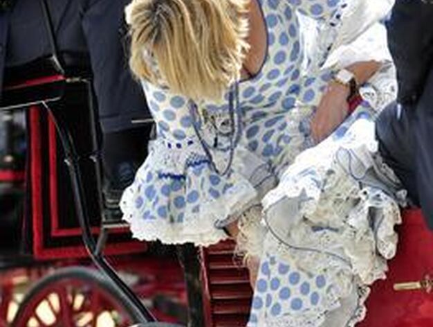 Una joven enreda los flecos de su mant&oacute;n en la rueda de un coche de caballo.

Foto: Manuel G&oacute;mez
