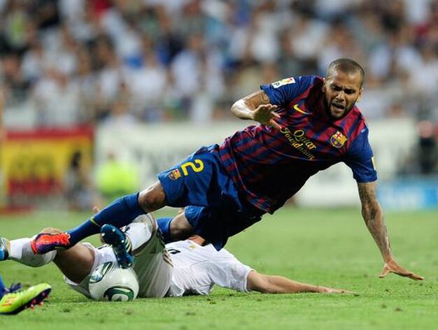 Dani Alves cae al c&eacute;sped tras una entrada. / AFP