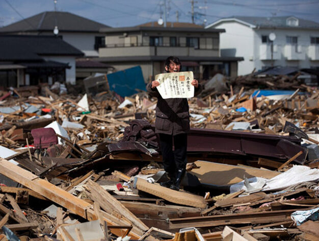 Chieko Masukawa muestra el certificado de graduaci&oacute;n de su hija, que ha encontrado entre los escombros tras el tsunami que arras&oacute; la ciudad de Higashimatsushima, en la prefectura de Miyagi. Es una imagen tomada de Yasuyoshi Chiba, de la agencia AFP. / Chieko Masukawa