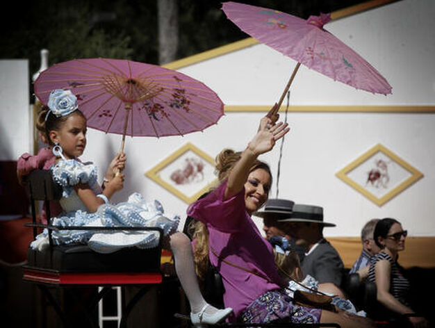 Un grupo de mujeres en un carruaje se protege del sofocante sol con unas sombrillas japonesas.

Foto: Miguel Angel Gonzalez