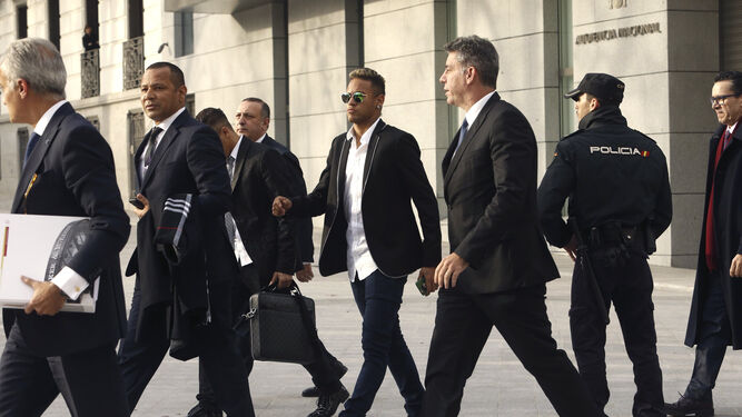El jugador del Barcelona Neymar, detrás de su padre, sale de la sede de la Audiencia Nacional en febrero.