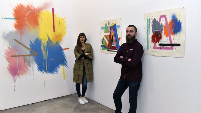 Los artistas y dueños de Delimbo Laura Calvarro y Seleka, en la galería ante tres de las obras del catalán Sixe Paredes.