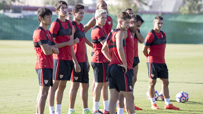 Varios jugadores del Sevilla esperan órdenes para una tarea en una sesión.