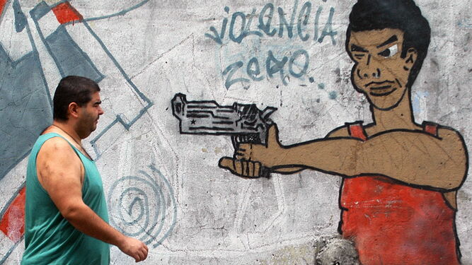 Un hombre pasa junto a un grafiti en un barrio de Río de Janeiro