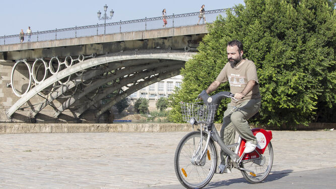 1. Uno de los usuarios de la bicicleta en el paseo junto al río.  2. Un coche eléctrico durante una acción promocional en la Plaza de España.