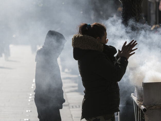 Una vendedora de casta&ntilde;as se calienta las manos en la Avenida de la Constituci&oacute;n, en Sevilla. Foto: Efe