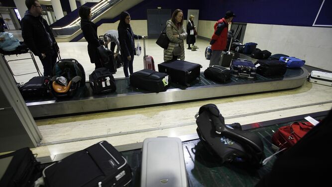 Usuarios esperan en las cintas de recogidas de equipaje.