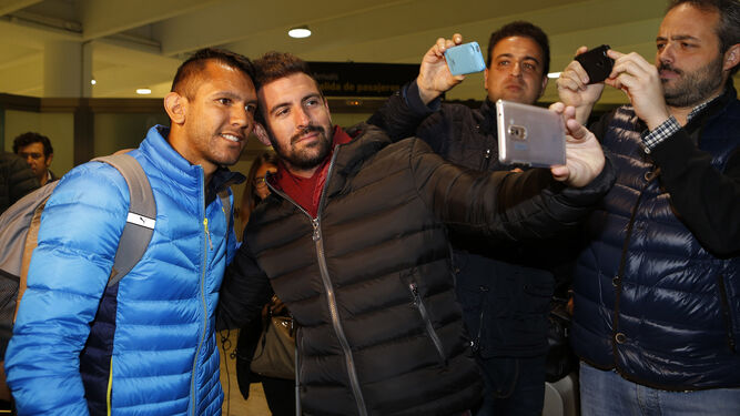 El centrocampista argentino Walter Montoya, a la izquierda, se hace un 'selfie' con un aficionado a su llegada al aeropuerto de San Pablo.