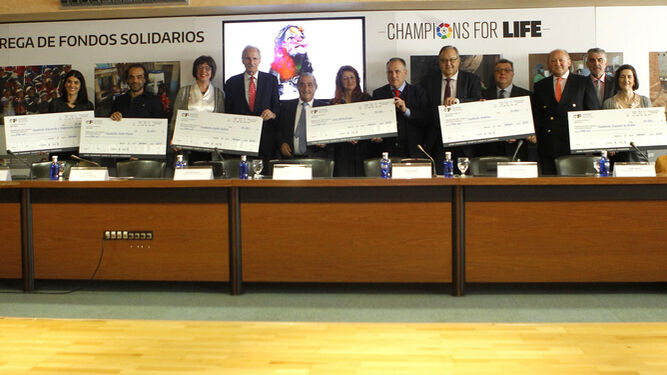 Los beneficiarios de los fondos por el encuentro 'Champions for Life' posan con sus respectivos cheques en la sede de La Liga.
