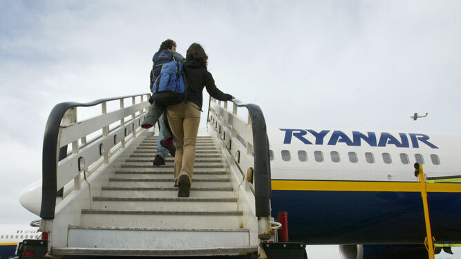 Dos pasajeros suben a un avión de Ryanair.