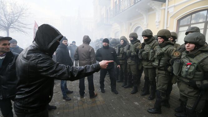 Un manifestante discutía ayer con policías durante una protesta en Kiev para reclamar que el Gobierno bloquee el comercio con los separatistas del este.