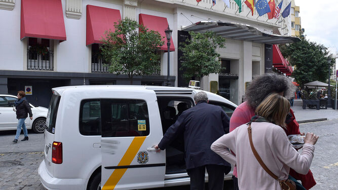 Turistas a punto de subirse a un taxi en el hotel Colón