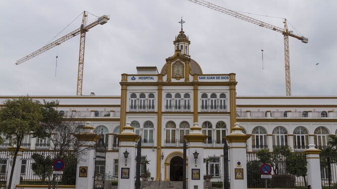Las grúas sobresalen de la fachada del Hospital de San Juan de Dios.