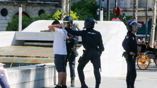 Agentes antidisturbios detienen a un joven.