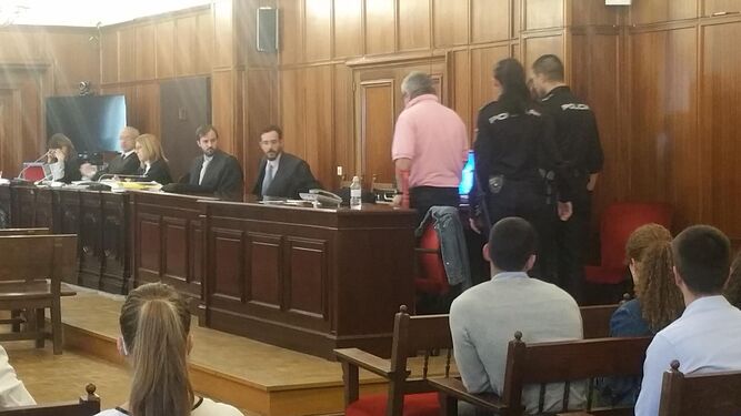 El acusado, de espaldas y con un polo de color rosa, durante una sesión del juicio.