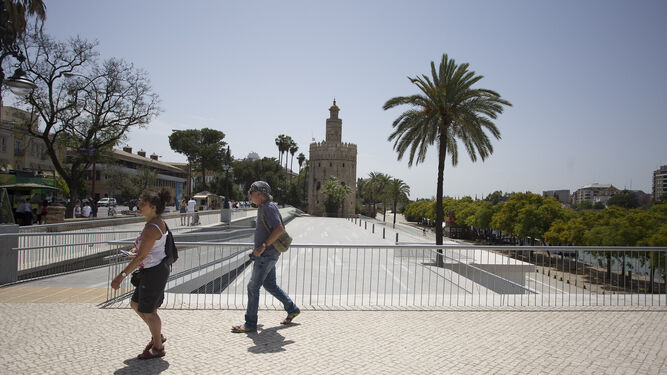 Dos turistas pasean bajo un sol de justicia por el nivel superior del paseo Marqués de Contadero.