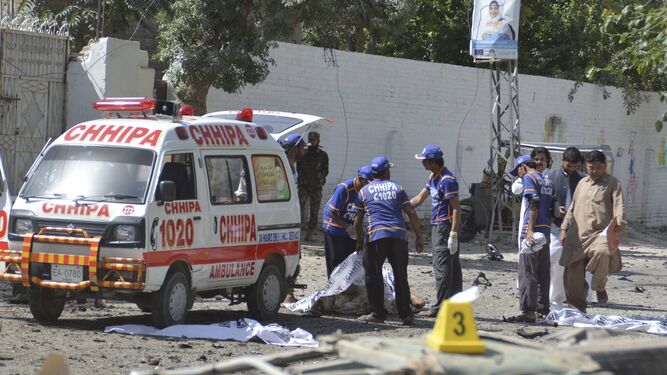 Trabajadores de los servicios de emergencia cubrían ayer el cuerpo de una víctima del atentado en Quetta.