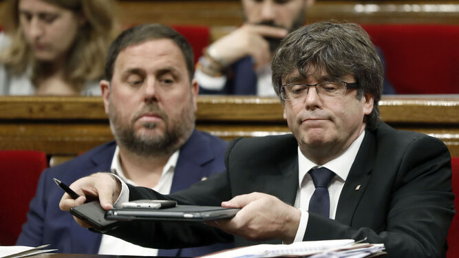 Carles Puigdemont y Oriol Junqueras en sus asientos del Parlament.