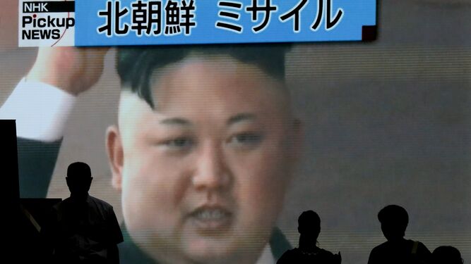Viandantes pasan en Tokio ante una pantalla gigante con Kim Jong-un.