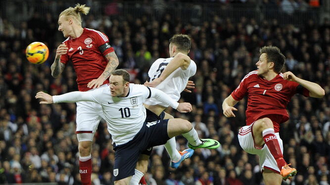 Kjaer gana un balón aéreo a Rooney en un Inglaterra-Dinamarca disputado en Wembley.