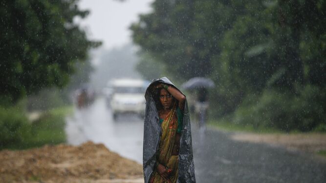 Una mujer camina bajo la lluvia en Nepal.