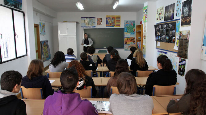 Los alumnos atienden las explicaciones del maestro en una clase bilingüe.