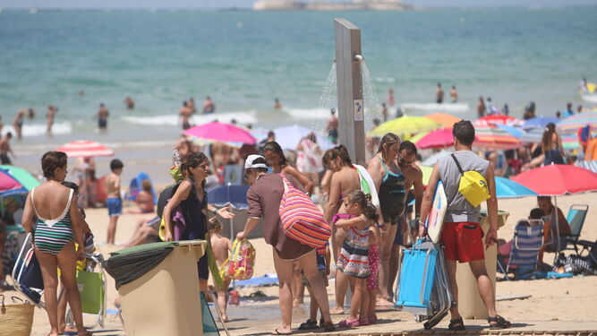 1. La playa de La Barrosa repleta de sombrillas y bañistas 2. Servicios de ducha en la segunda pista. 3. La playa chiclanera dispone de multitud de zonas recreativas para niños.