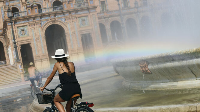 Una joven pasea en bicicleta por la Plaza de España.