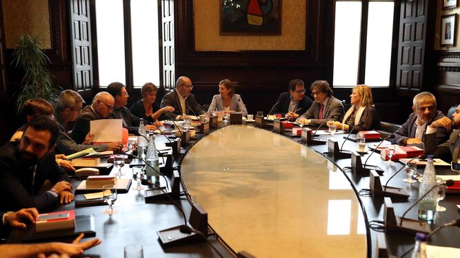 Carme Forcadell, presidenta del 'Parlament' -en el centro de la imagen-, dialoga con los miembros de la Mesa de la Cámara catalana antes de reunirse ayer.