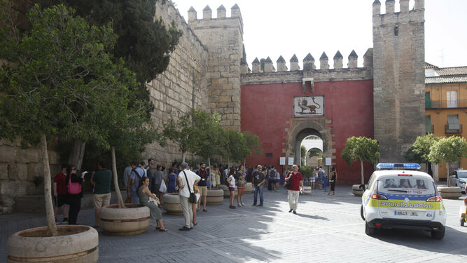 Una fila de turistas espera en la Plaza del Triunfo para acceder al Real Alcázar a través de la Puerta del León.