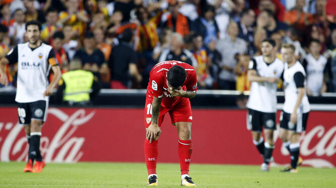Banega se lamenta mientras Guedes celebra al fondo uno de sus dos goles al Sevilla.