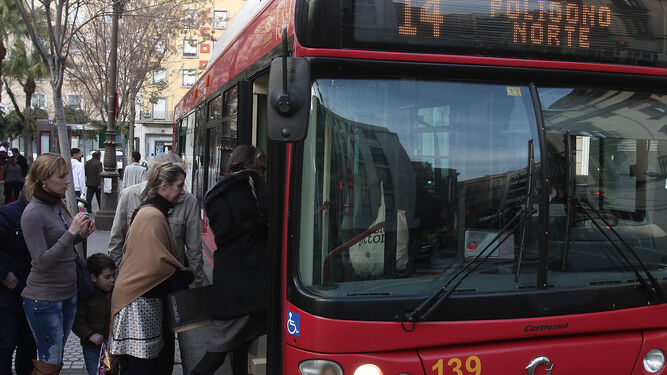 Varios viajeros acompañados de un menor de 12 años acceden a un autobús de la línea 14.