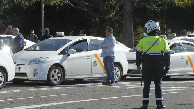 Un policía local controla a un grupo de taxistas, en una imagen de archivo.