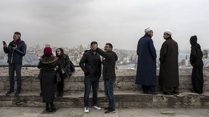 Visitantes a la mezquita de Solimán disfrutan de las vistas de Estambul desde lo alto de una de las siete colinas que dominan el Cuerno de Oro.