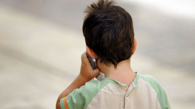 Un niño hablando por un teléfono móvil.