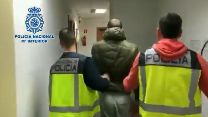 Dos agentes con uno de los detenidos, ya en dependencias policiales.