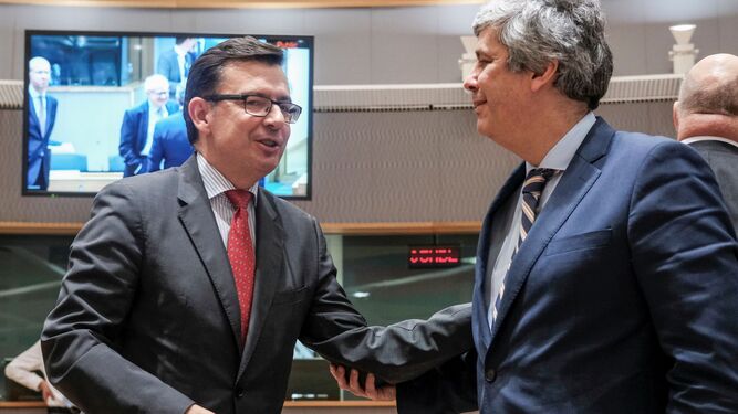 El ministro de Economía, Román Escolano (izqda.), saluda al presidente del Eurogrupo, Mario Centeno.