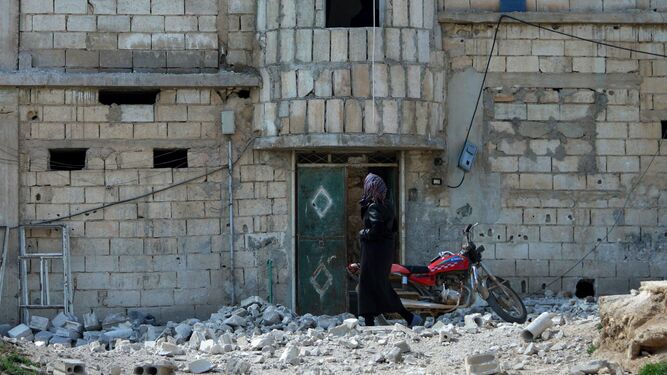 Una mujer inspecciona los destrozos tras una bomba, ayer en Idlib.