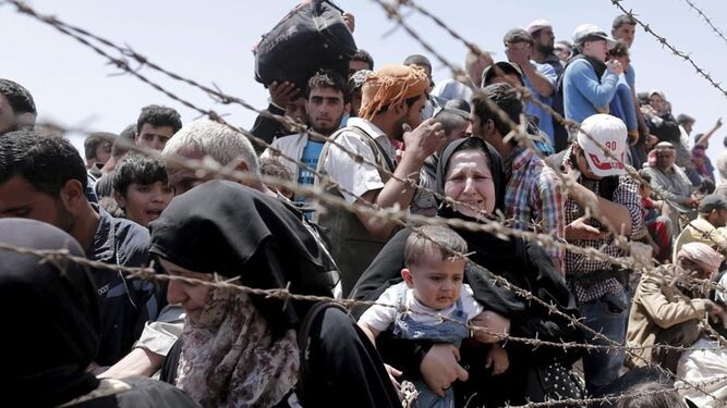 Refugiados sirios en  la frontera que les separa de Turquía.