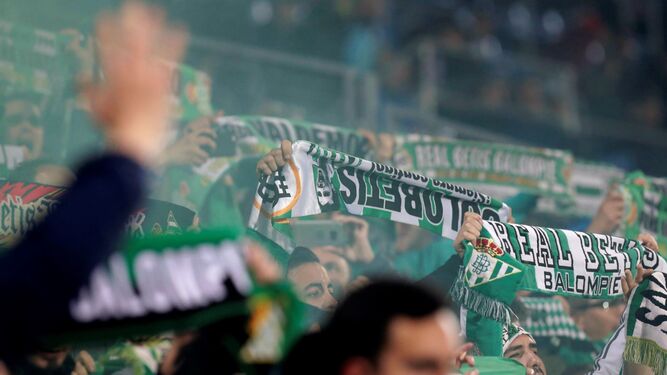 Un grupo de aficionados del Betis presentes en Getafe despliegan las bufandas antes del comienzo del choque.