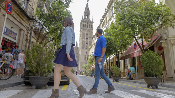 Dos personas cruzan por un paso de peatones situado a la mitad de Mateos Gago.