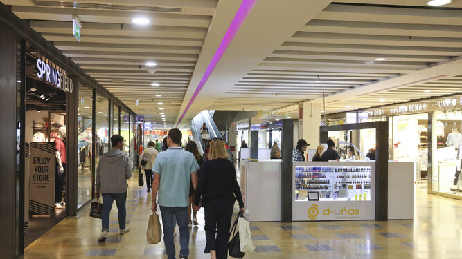 Varias personas compran y pasean por un centro comercial de Málaga.