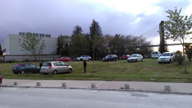 Decenas de vehículos aparcados en una pendiente del parque, junto al centro deportivo Bermejales, este lunes.