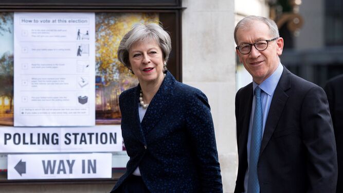 La primera ministra británica, Theresa May, llega junto a su marido al centro electoral londinense donde votó ayer.