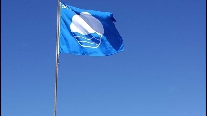 Bandera azul ondeando en una playa.