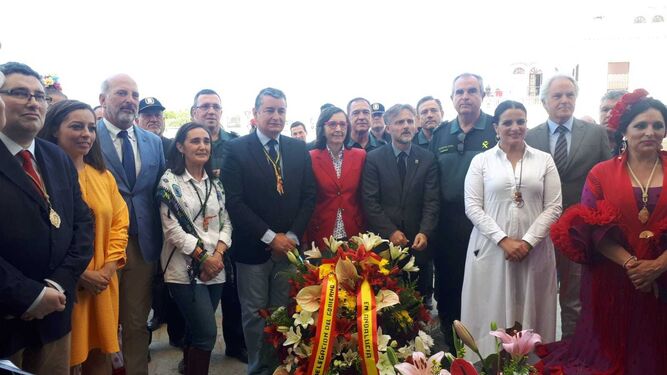 Las autoridades asistentes a la presentación del Plan Aldea entregan un centro de flores a la Virgen del Rocío.