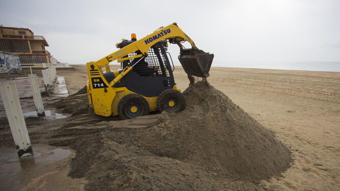 Una máquina trabaja apartando arena de los chalés de La Antilla.