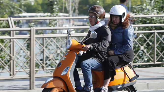 Dos personas se protegen del frío para circular en moto.