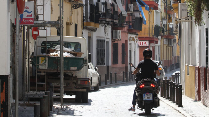 Un motociclista circula por Rodrigo de Triana, que cuenta con numerosos pisos turísticos.